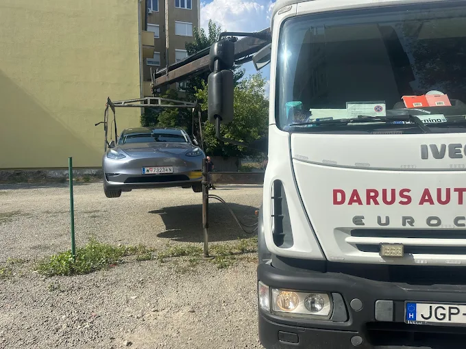 Elektromos Tesla Model 3 az autószállító platóján, óvatos rögzítéssel
